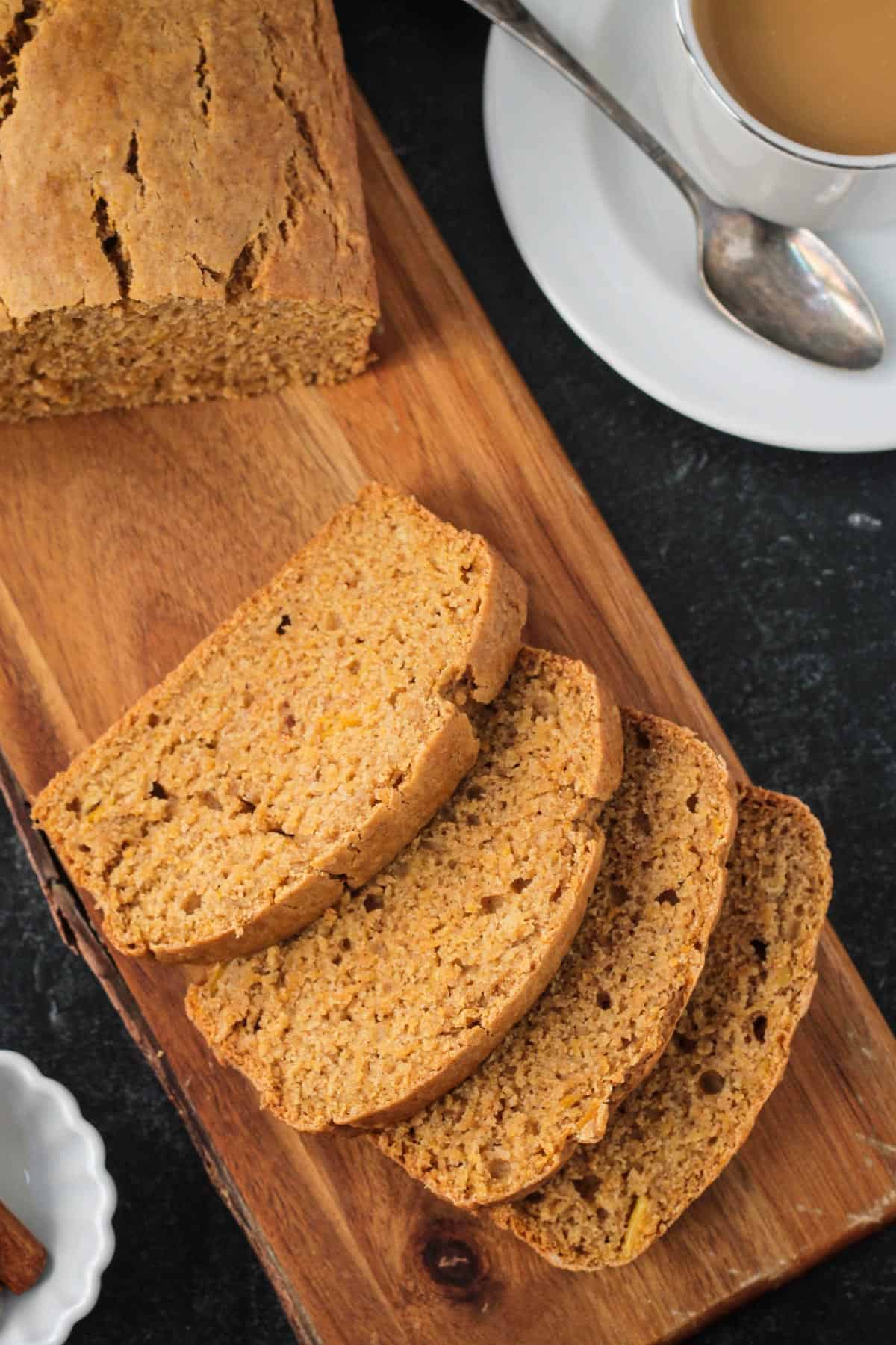 Cinnamon Squash Bread - A fall inspired quick bread packed with creamy butternut squash and warming spices. Enjoy a slice for breakfast, dessert or an afternoon snack. Loaf of butternut squash bread sliced on a serving board.