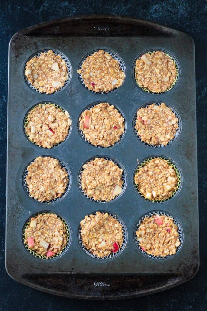 Oat muffin batter in a muffin pan.