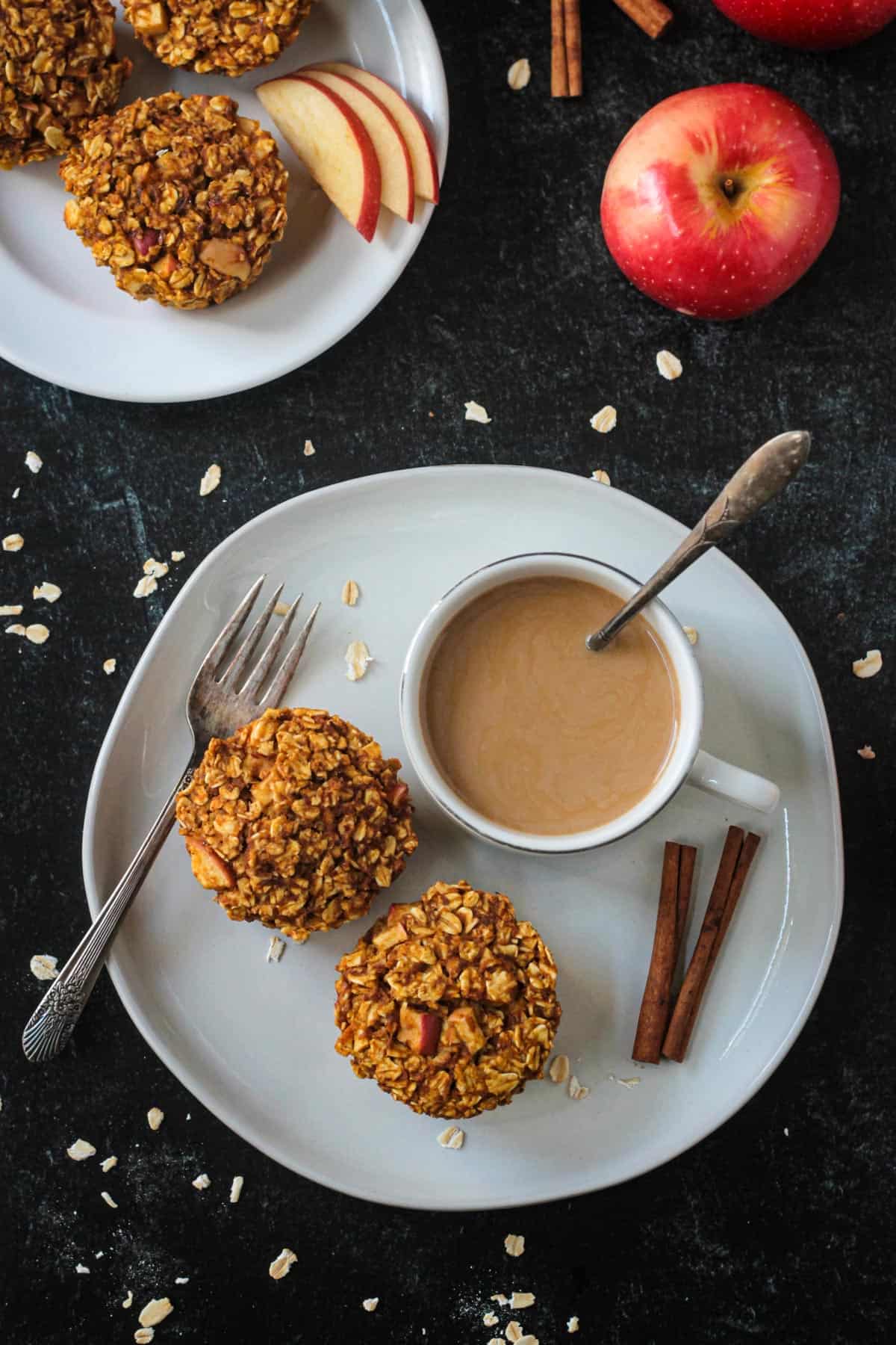 Two baked oatmeal cups on a plate with a cup of coffee.