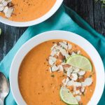 Overhead view of a sweet potato soup recipe in a white bowl on a blue napkin.