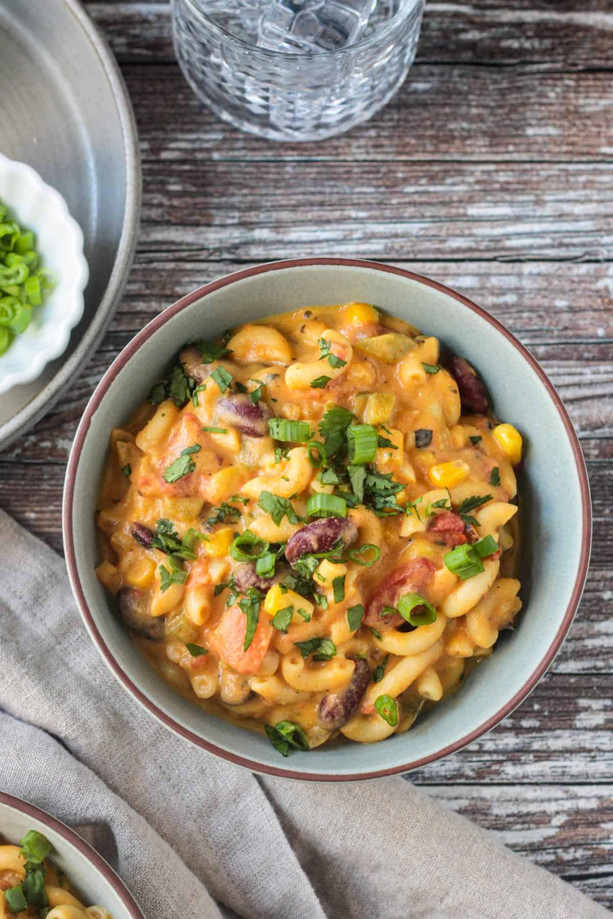 Bowl of vegan chili mac with kidney beans topped with chopped fresh cilantro.