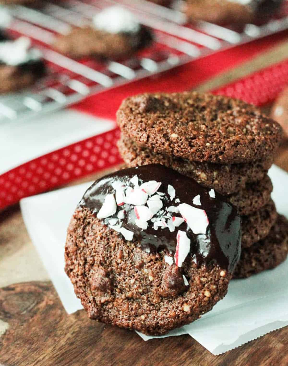 Close up of melted chocolate and crushed peppermint candies on a chocolate molasses cookies.