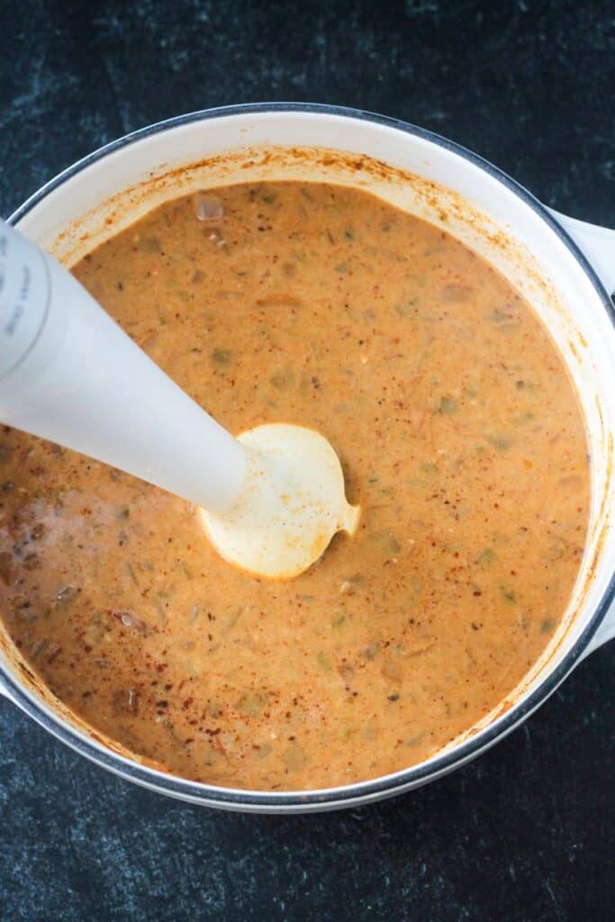 Immersion blender in a pot of chili.