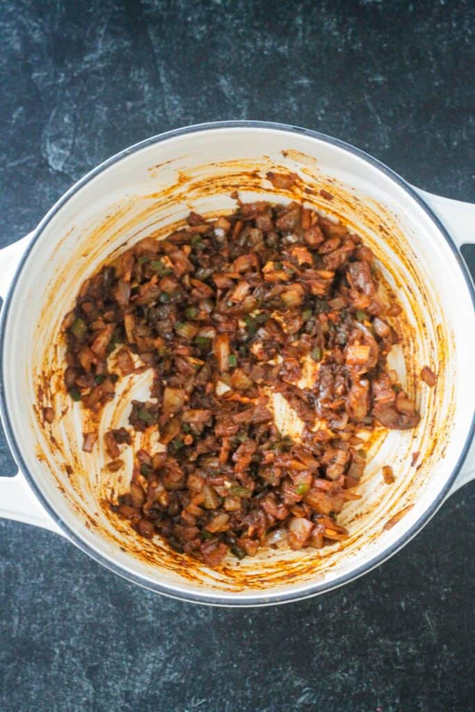 Onions sautéed with chili spices in a pot on the stove.