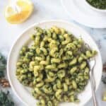 Cellentani pasta with pesto on a white plate.