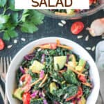 Chopped kale salad with a variety of vegetables in a white bowl.