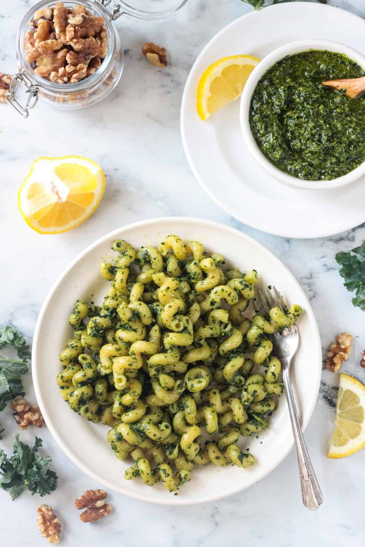 Cellentani pasta with pesto on a white plate.