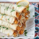 Pile of baked Chickpea and Artichoke Vegan Taquitos on a platter.