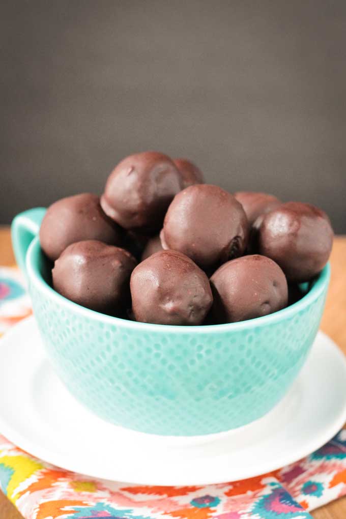 Large blue mug of chocolate dessert bites on a white plate.