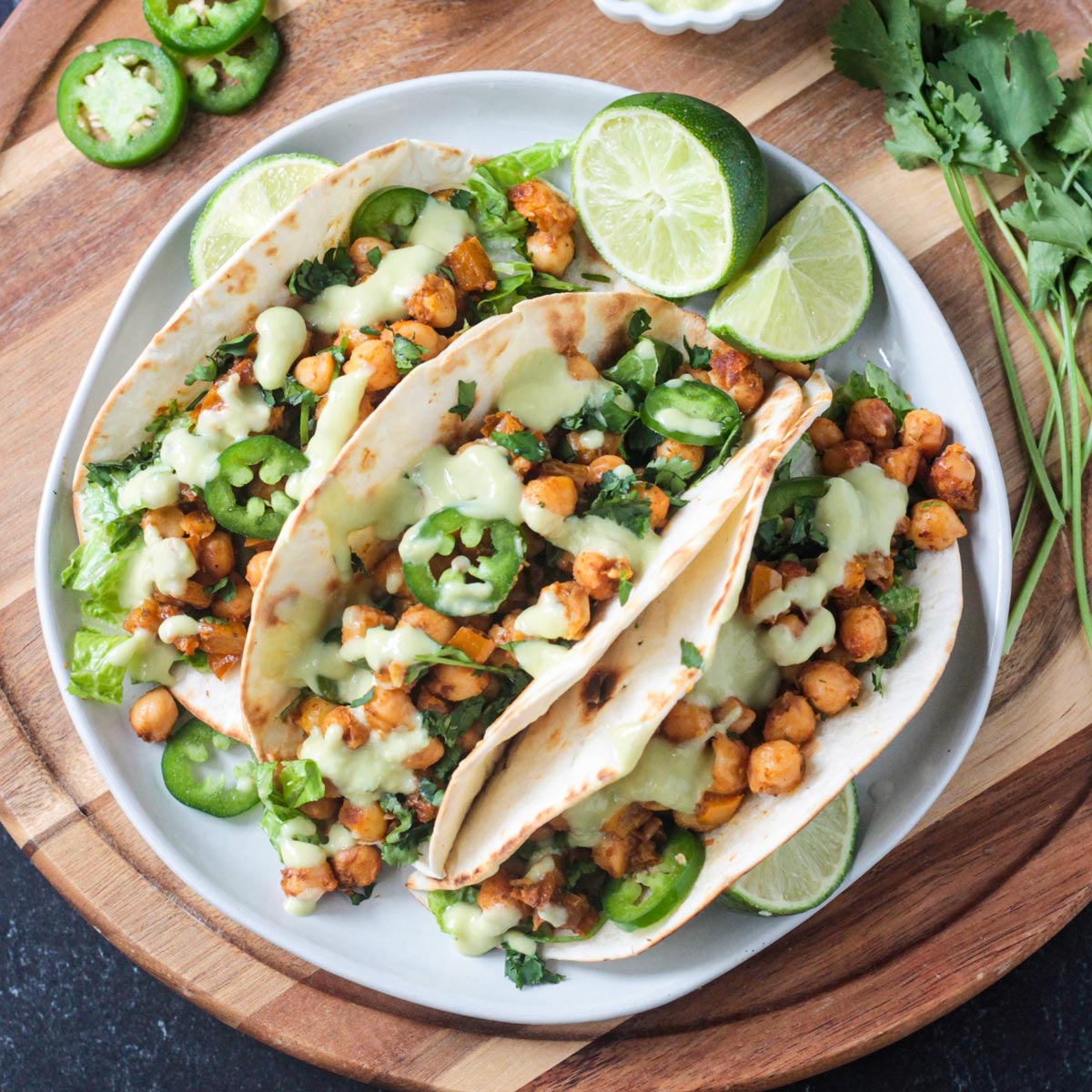 Three vegan chickpea tacos on a dinner plate.