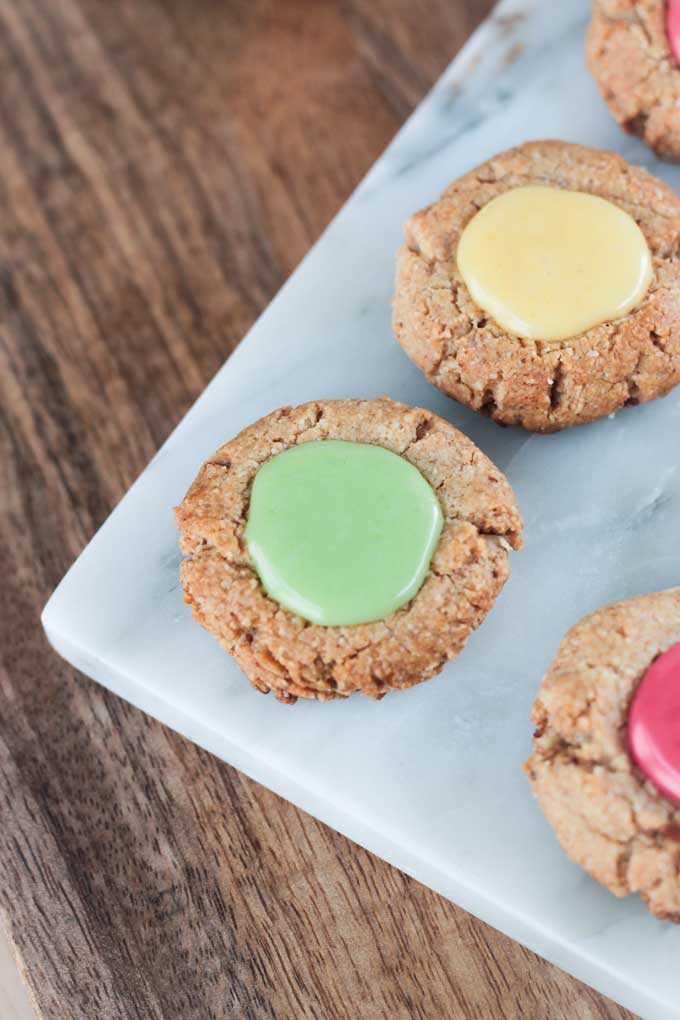 Close up overhead view of a Gluten Free Thumbprint Cookie with green pastel icing.