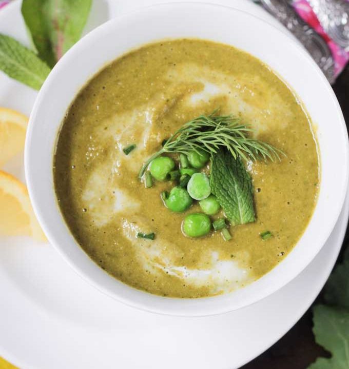 Creamy green vegetable soup topped with green peas, fresh dill, & mint leaf.