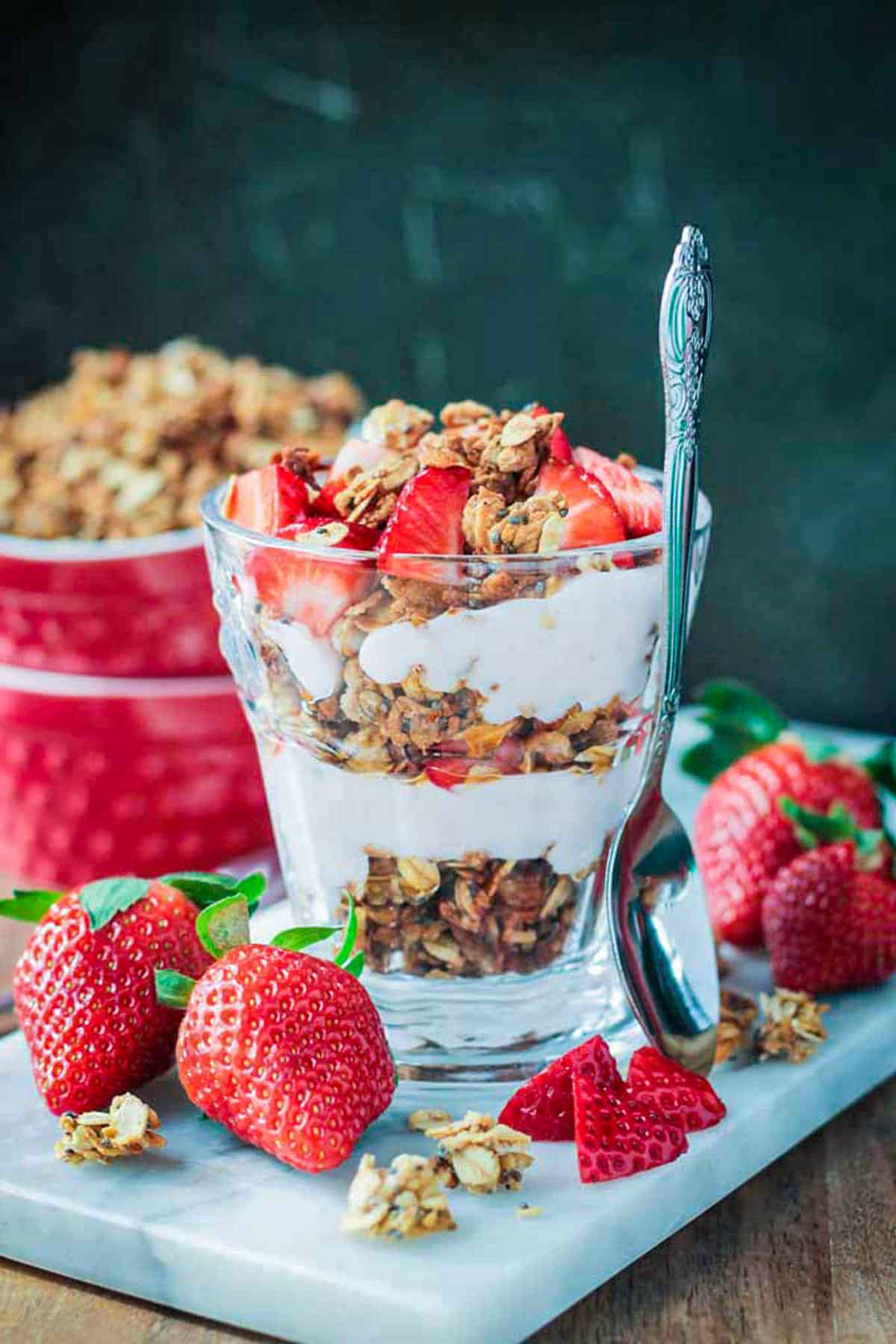 Coconut Chia Granola layered with dairy free yogurt and fresh strawberries in a parfait glass