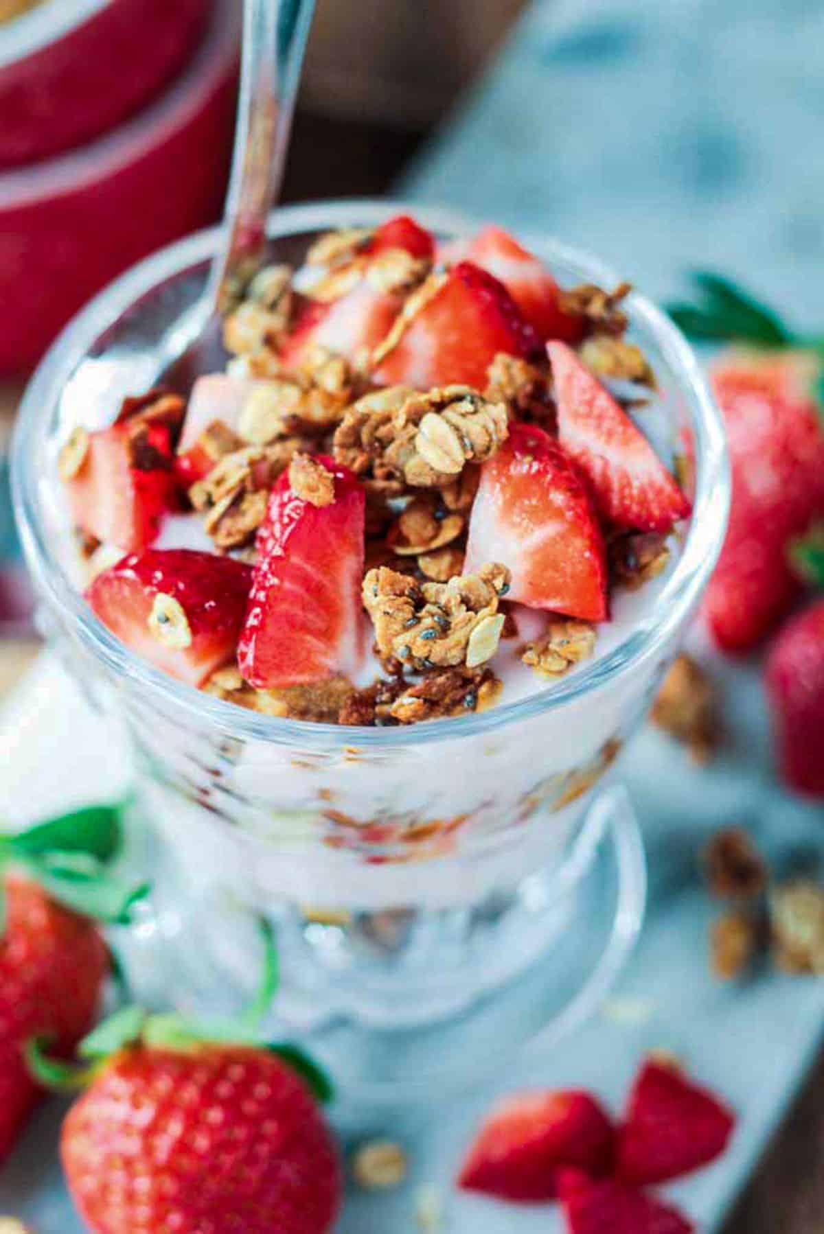 Overhead view of granola and fresh fruit in a glass.