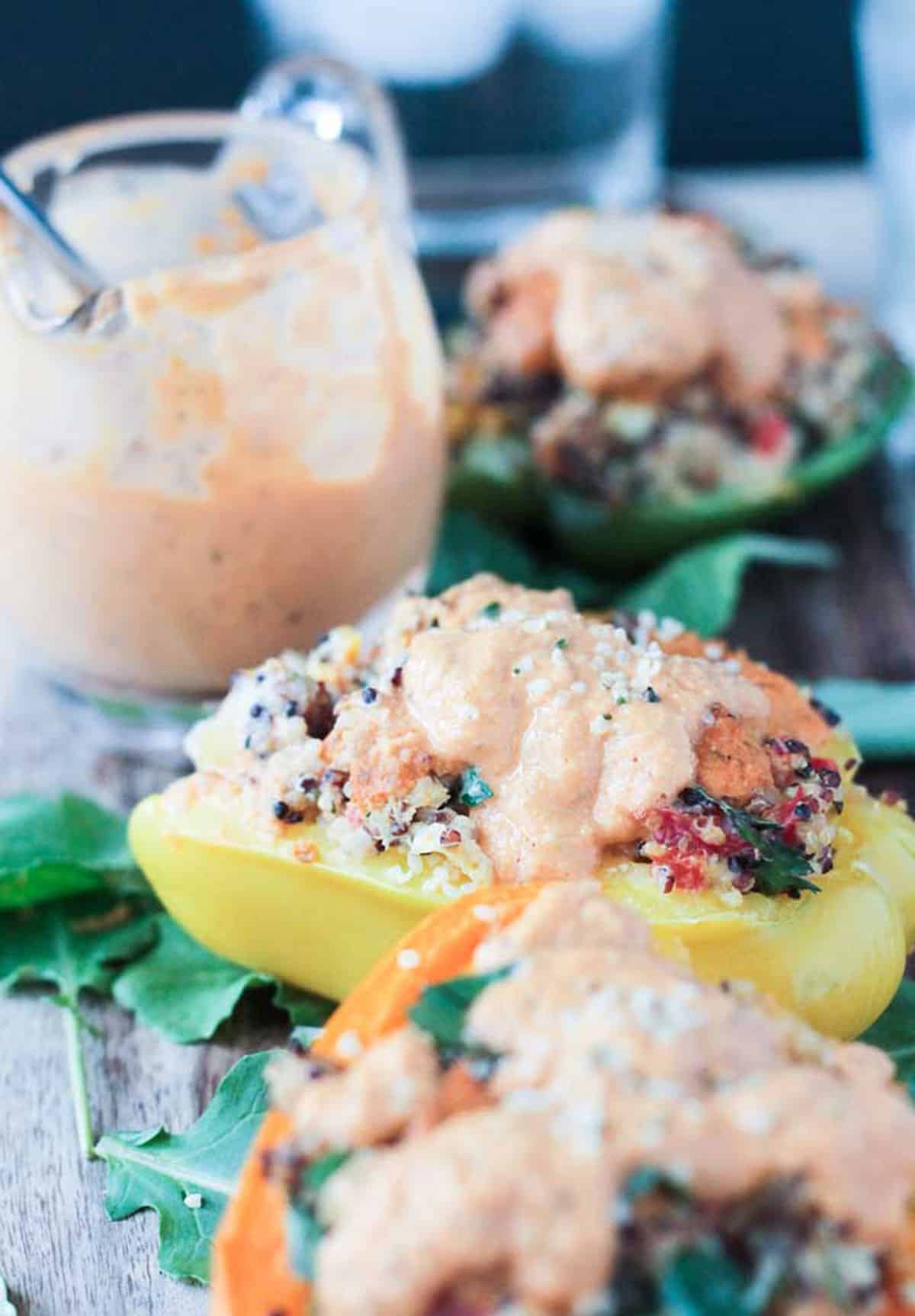 Creamy roasted red pepper drizzled on top stuffed peppers.