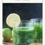 Green juice in a glass with a lemon slice on the rim.