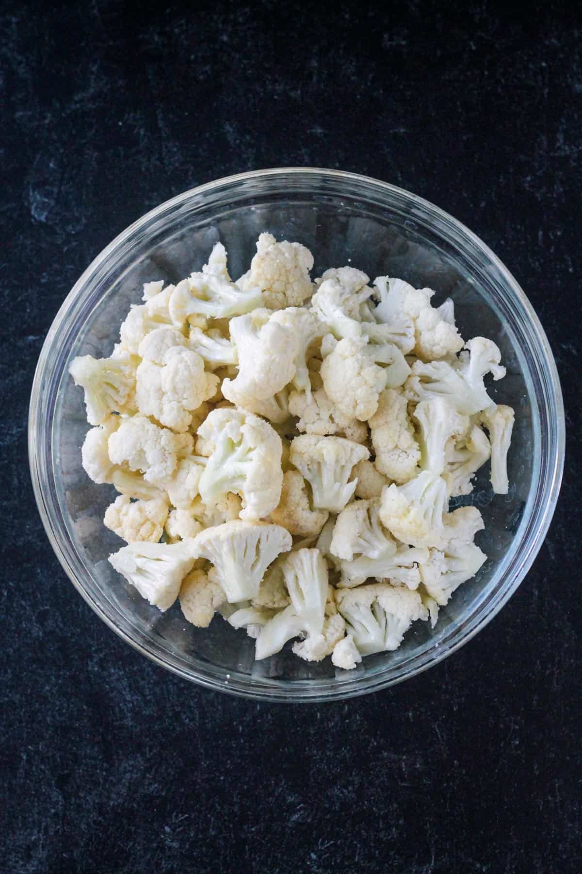 Cauliflower florets in a glass bowl.