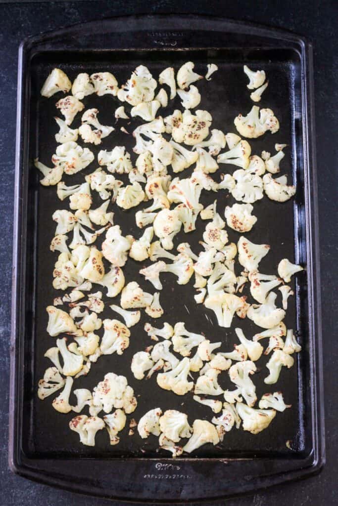 Roasted cauliflower on a rimmed baking sheet.
