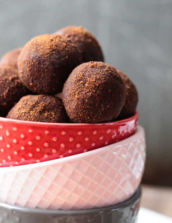 A pile of Cinnamon Chickpea Dairy Free Truffles dusted in cinnamon sugar in a bowl.
