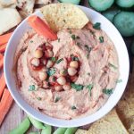 Bowl of spicy hummus topped with extra salsa, chickpea, and cilantro.