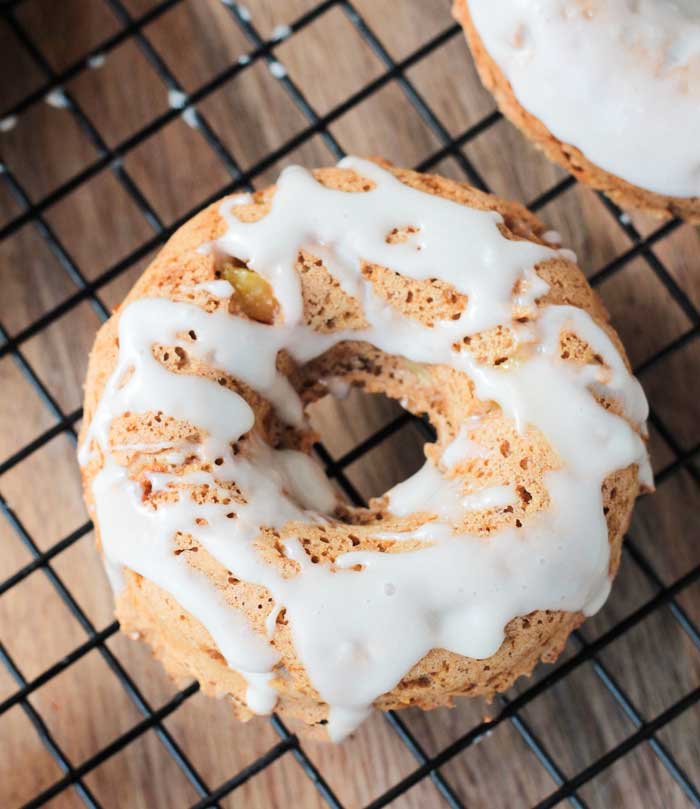 One Peaches and Cream Dairy Free Donut on a cooling rack. White icing is drizzled in a zig zag pattern over the donut.