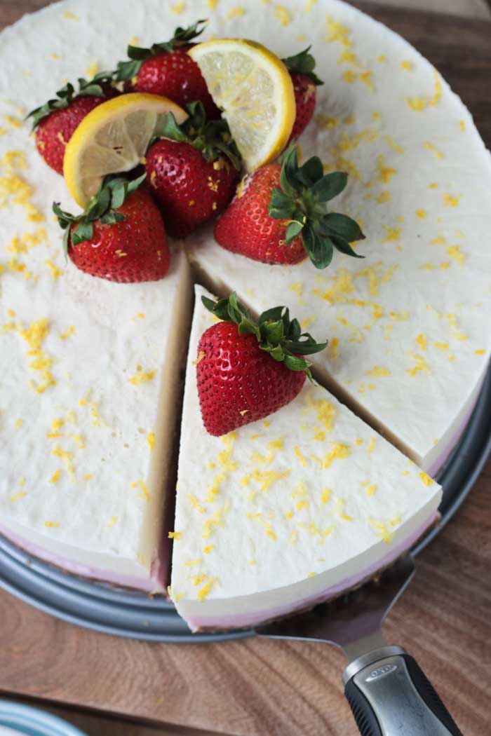 One slice being cut from a strawberry lemonade ice cream cake.