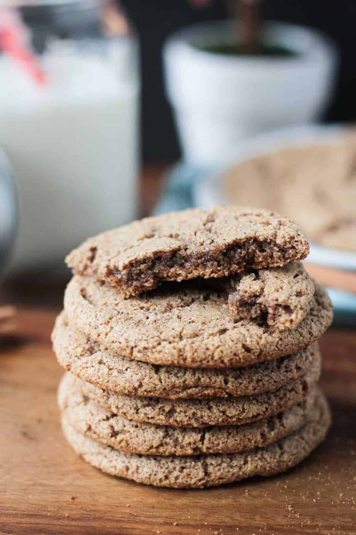 Cinnamon Sugar Cookies - perfectly crispy on the outside, chewy on the inside, sweet, delicious, and packed with warm cinnamon. Only 6 ingredients and 15 minutes needed to make these quick and easy, gluten free cookies! They're going to become your go-to sweet treat! Broken cookie on top of a stack of perfectly round ones.