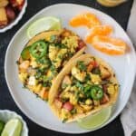 Two vegan breakfast tacos filled with tofu scramble and roasted potatoes.