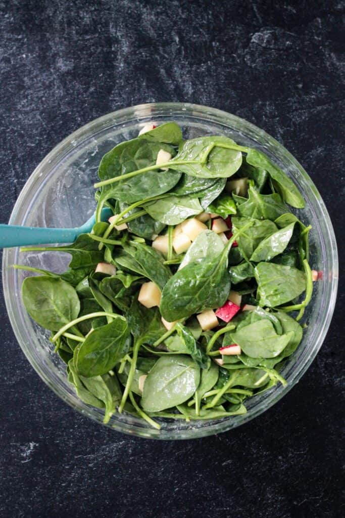 Baby spinach and chopped apples tossed with the dressing.