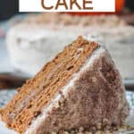 Slice of pumpkin layer cake on its side on plate with the full cake behind.