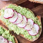 Vegan avocado toast with thinly sliced radishes and hemp seeds.