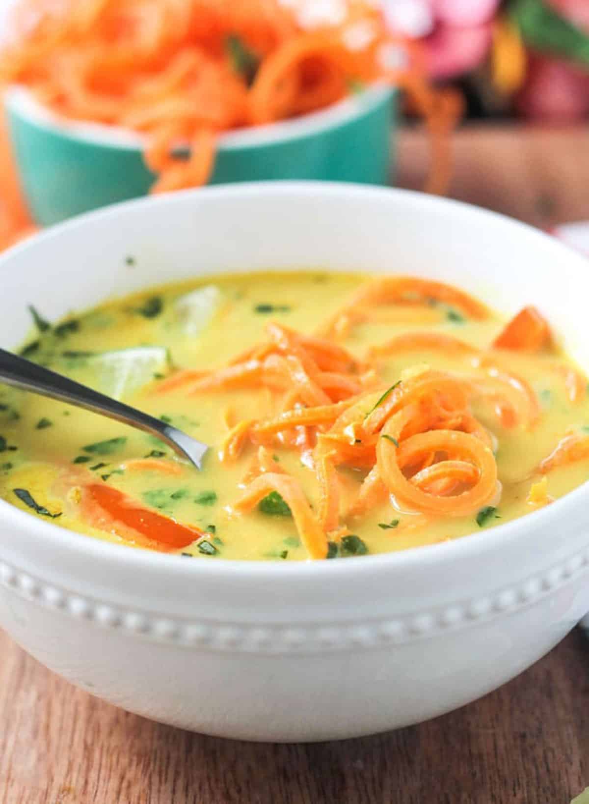 Close up of sweet potato noodles in a bowl of curry soup.