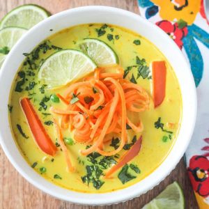 Golden yellow coconut curry soup topped with spiralized sweet potatoes and fresh cilantro.