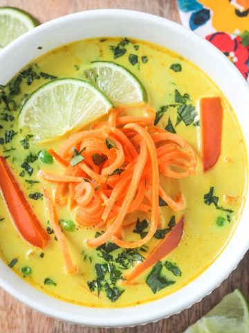 Golden yellow coconut curry soup topped with spiralized sweet potatoes and fresh cilantro.