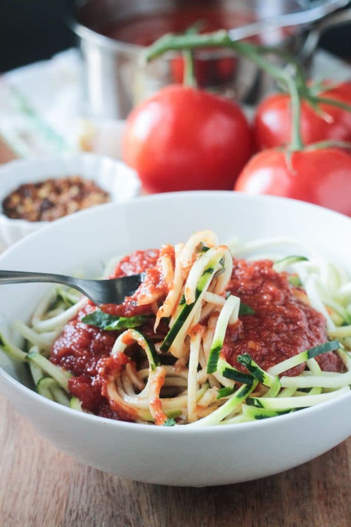 Zucchini noodles twirled around a fork.