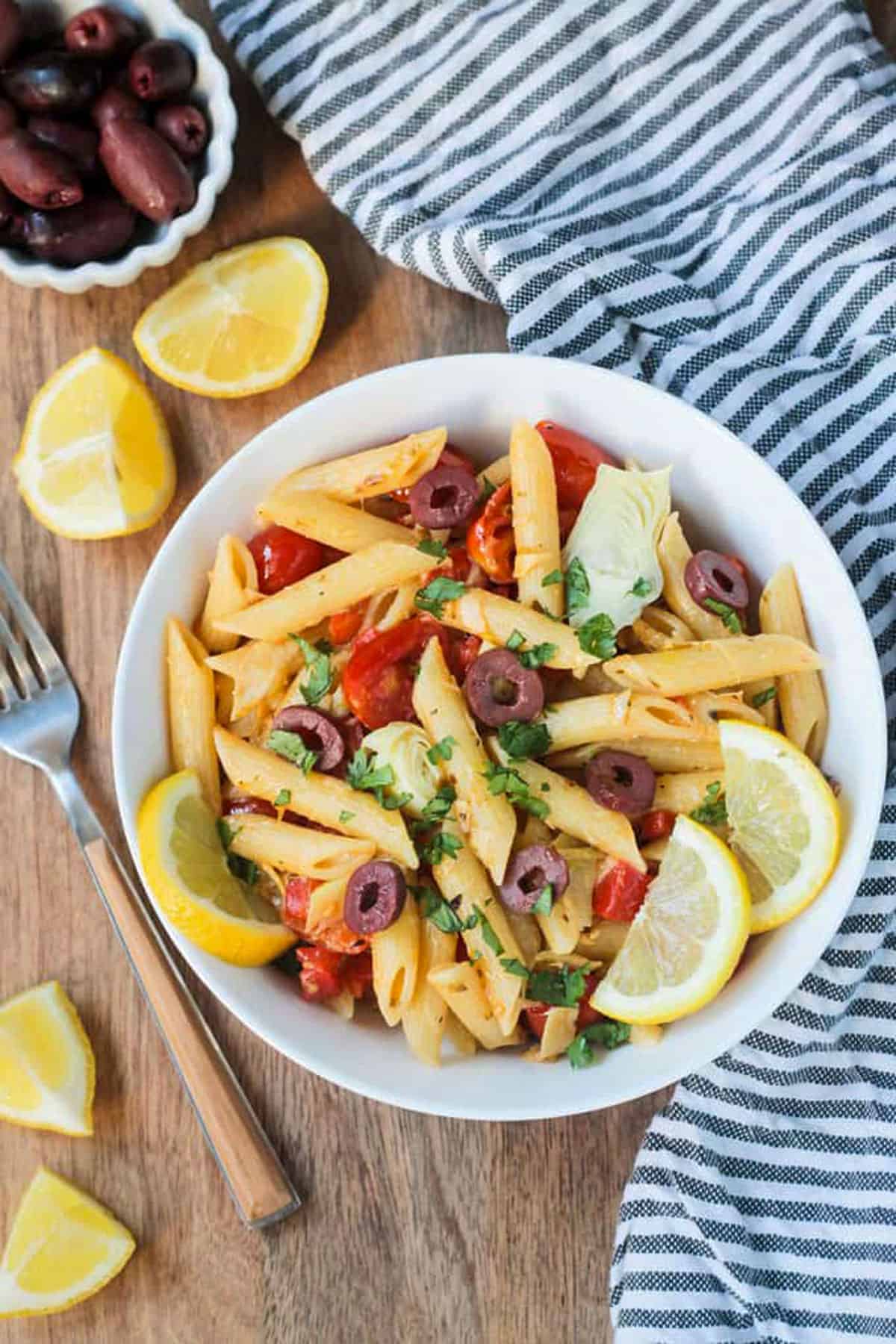 Penne with roasted red peppers and artichokes in a bowl.