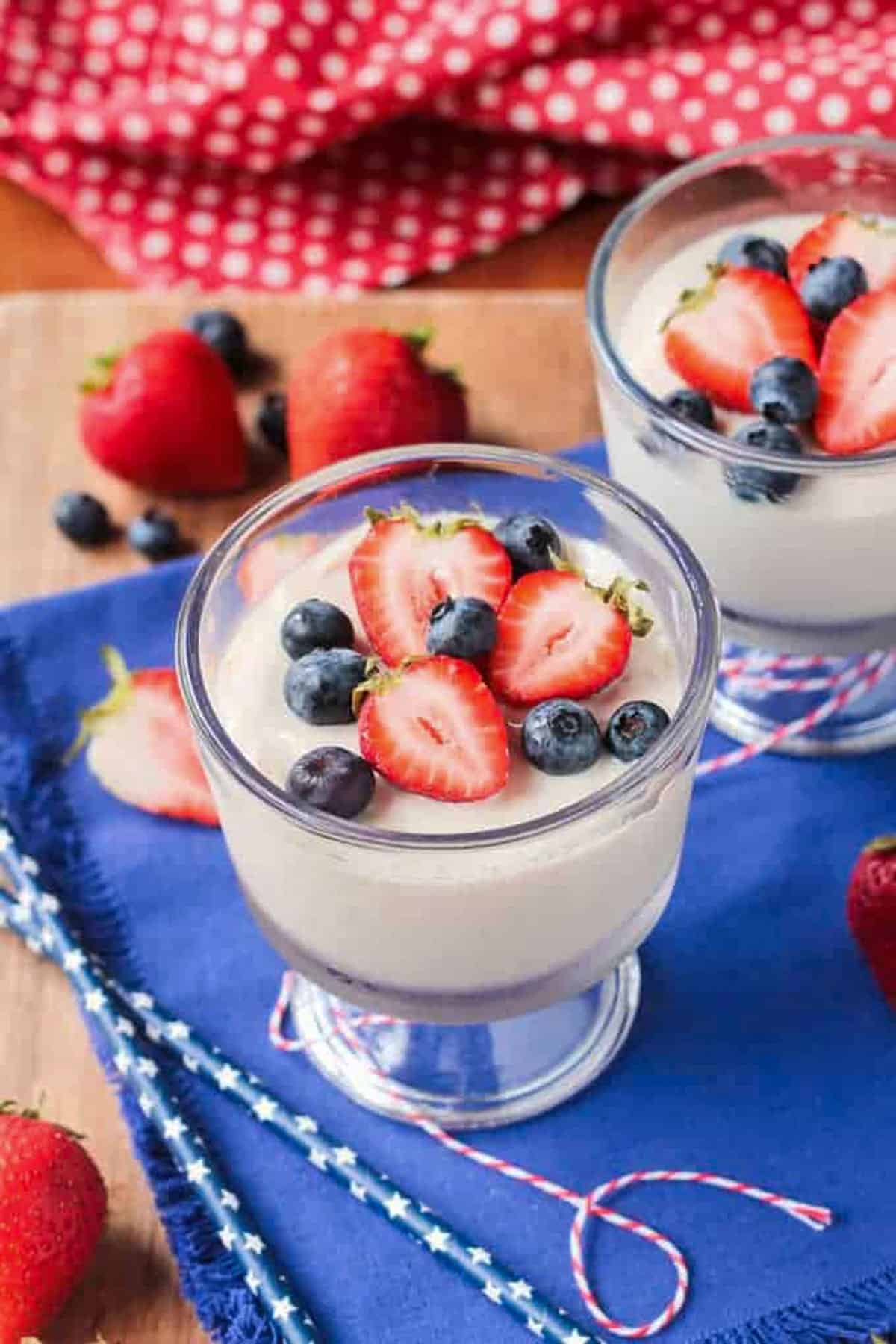 Vegan vanilla pudding in a glass bowl topped with fresh berries.