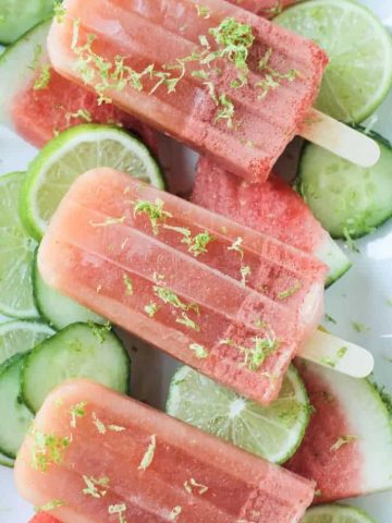 Close up shot of a watermelon popsicle garnished with lime zest.