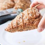 Hand holding a Banana Black Sesame Vegan Scones with Maple Tahini Glaze.