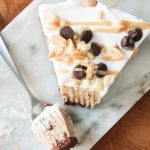 Slice of frozen chocolate chip pie with a bite taken out with a fork.