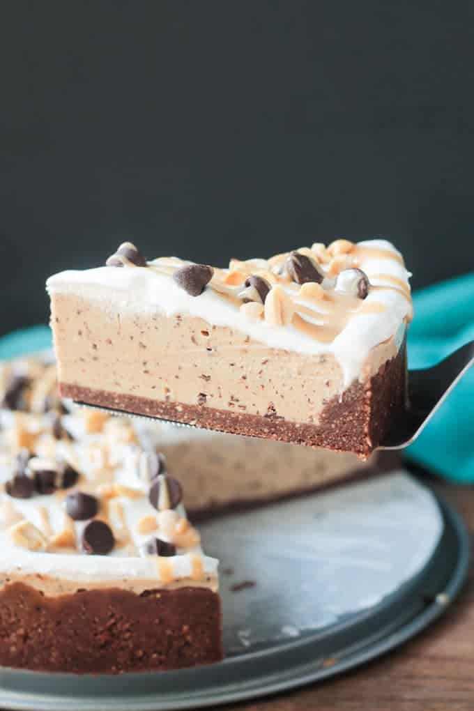 Slice of chocolate chip peanut butter pie being lifted from the whole pie with a spatula.