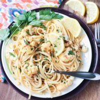 Plate of Cauliflower Scampi in Lemon Garlic White Wine Sauce garnished with wedges of lemon and fresh parsley.