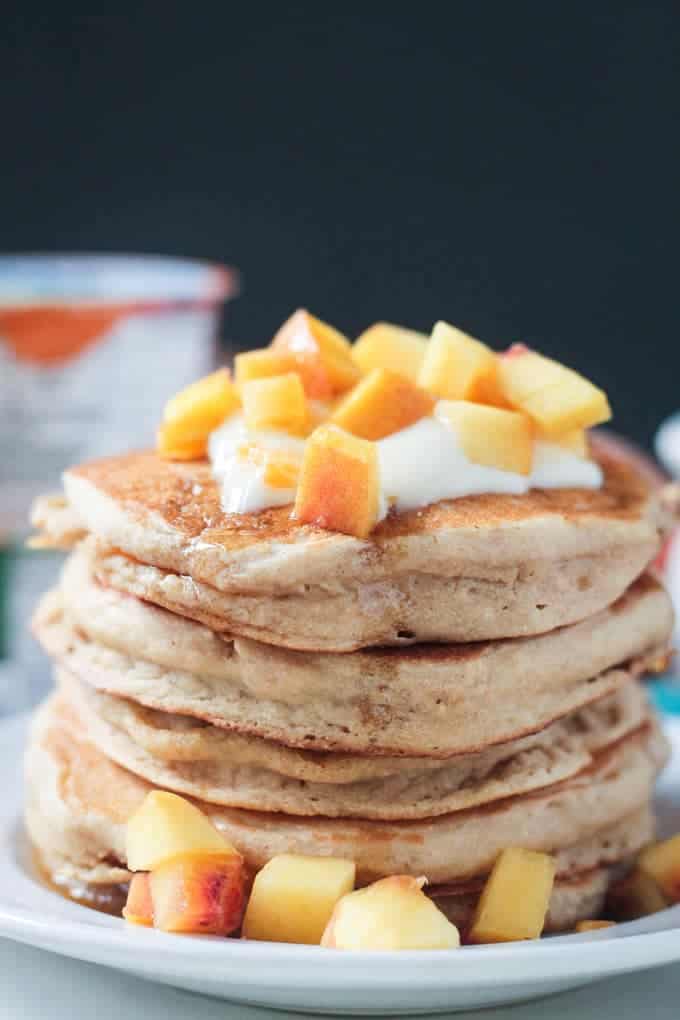 Close up photo of a stack of 5 peach pancakes.