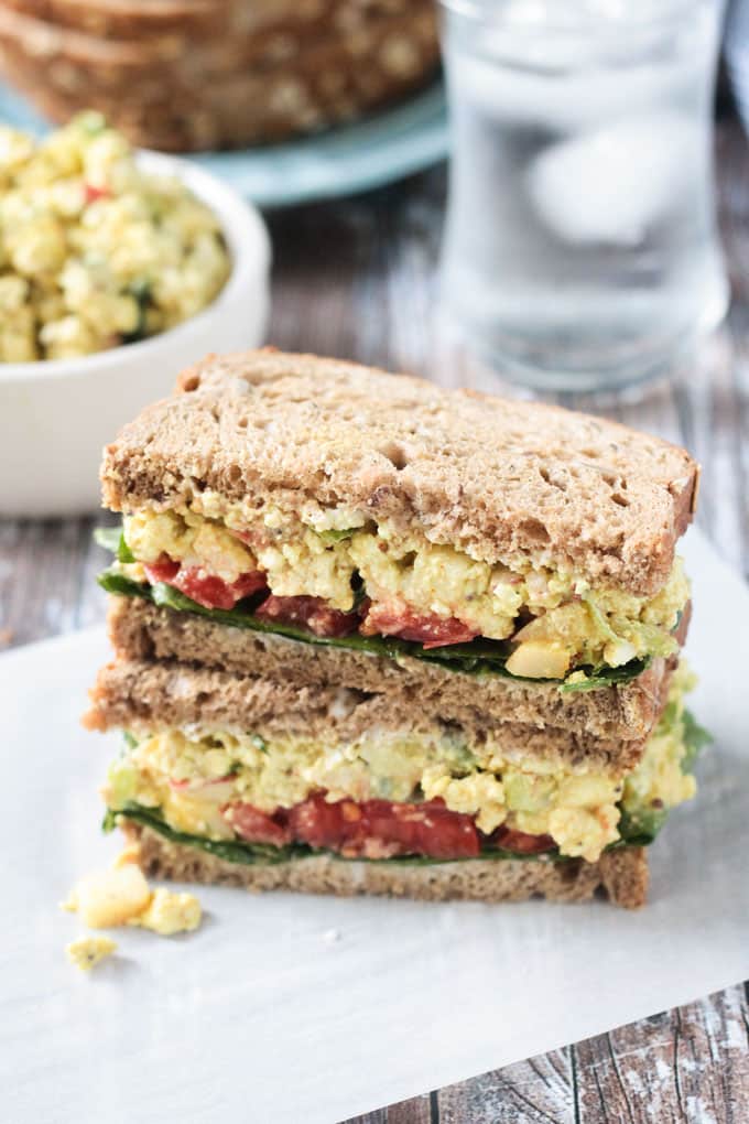 Two halves of a Curried Tofu Sandwich stacked on top of a each other.