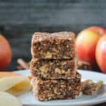 Stack of three apple oat date bars on a white plate.