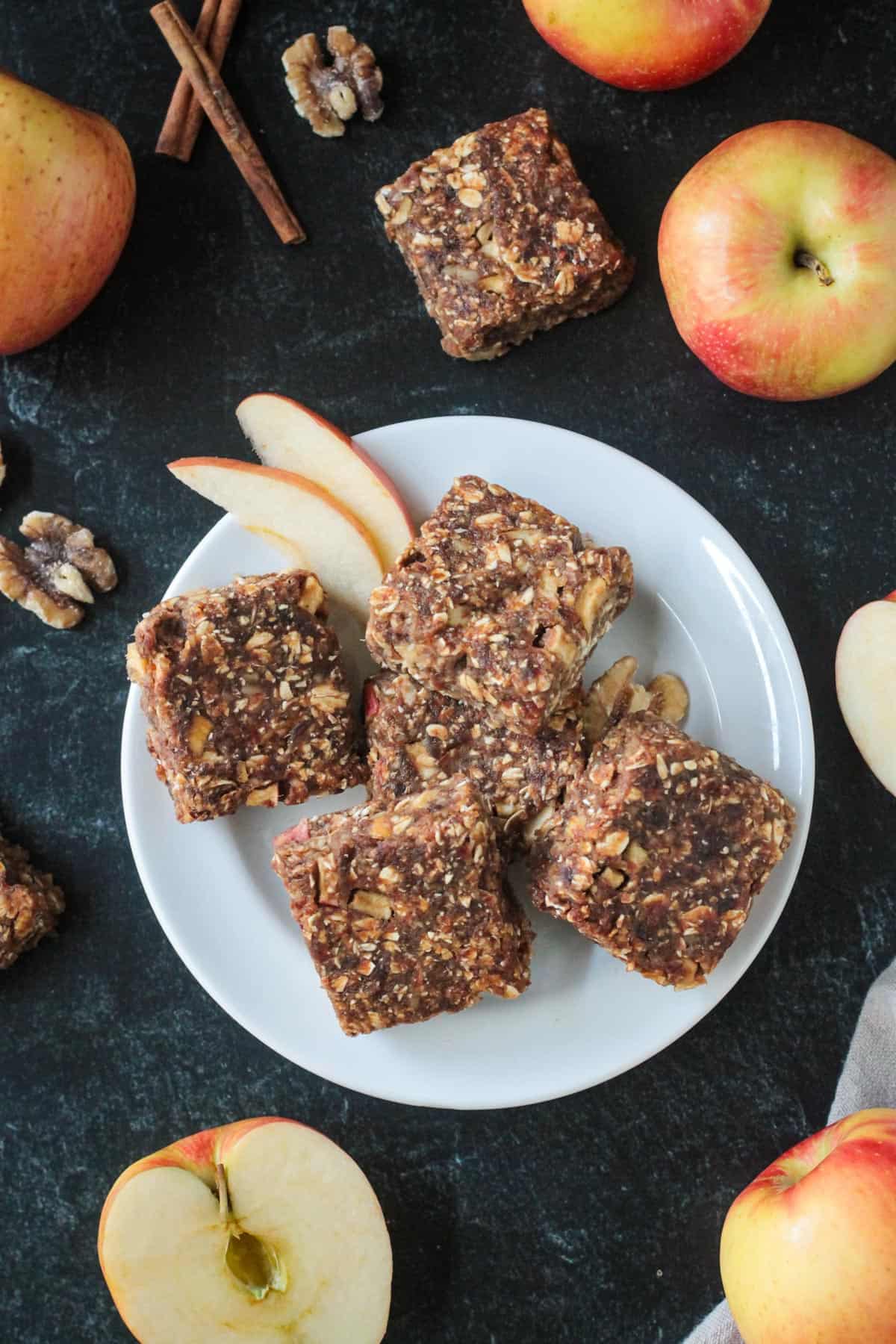 Sugar Free Apple Pie Bars - soft, chewy bars that taste just like apple pie. Kind of like apple pie meets apple cake meets apple baked oatmeal. Sweet and delicious with absolutely no added sugar - fruit sweetened! Gluten free and vegan, these bars make the perfect breakfast, snack, or dessert. A pile of baked date bars on a plate.