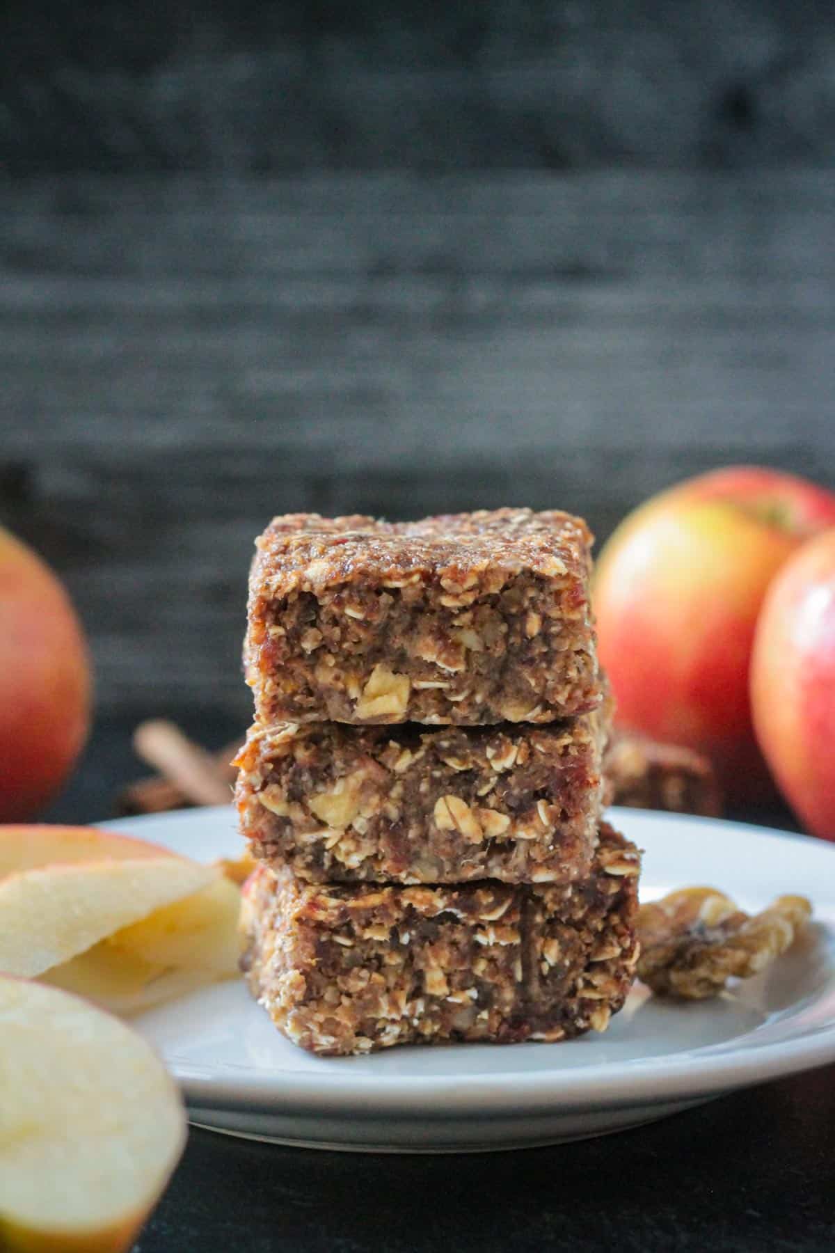 Stack of three apple oat date bars on a white plate.