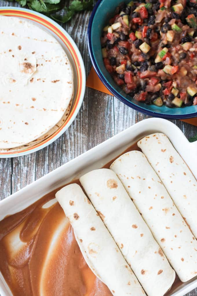 Pan of enchiladas being filled.