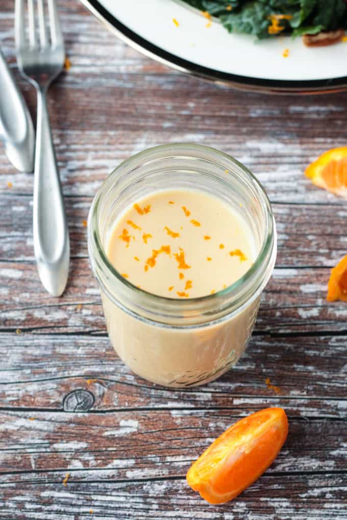 Overhead view of a jar of dressing sprinkled with orange zest.