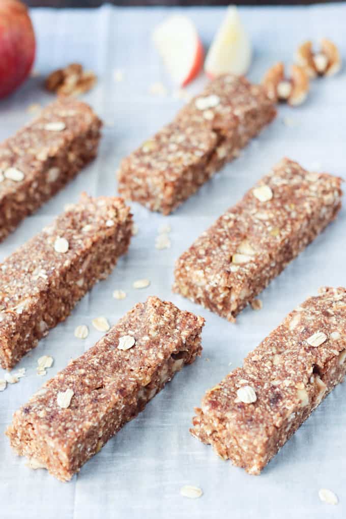 Apple pie bars lying on a parchment paper lined baking sheet.